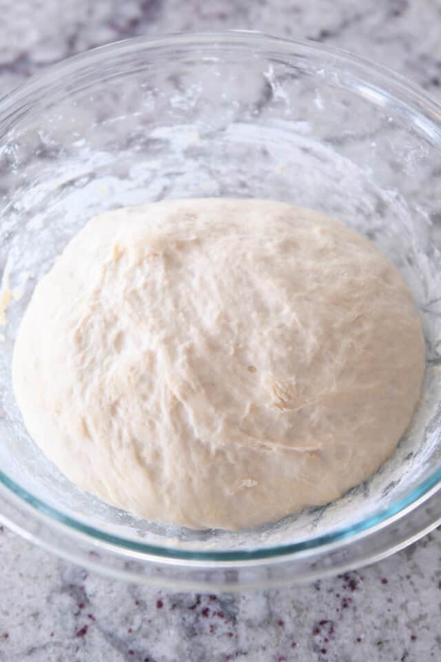 Risen breadstick dough in glass bowl.