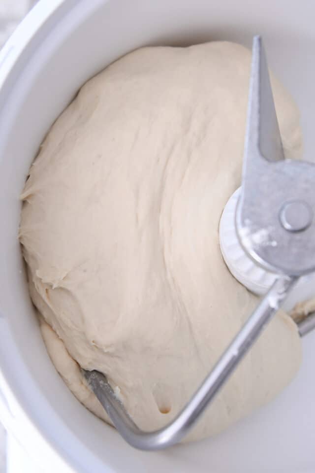 Risen dough in white bosch mixer bowl.