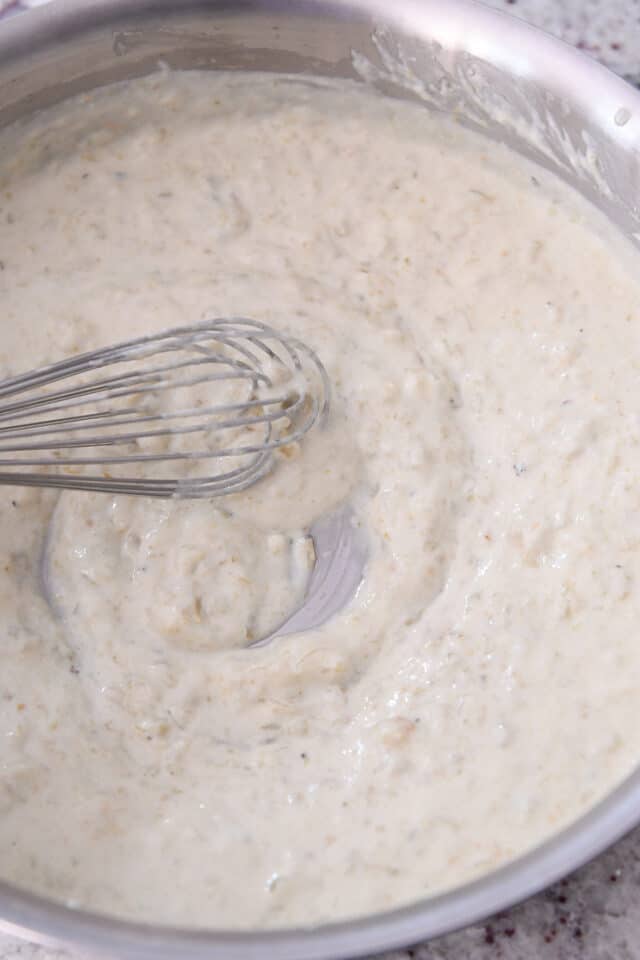 Stainless steel saucepan with cream sauce for enchiladas.