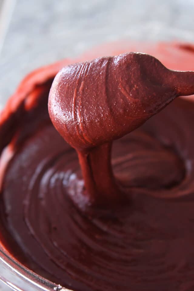 Spatula stirring red velvet brownie batter.