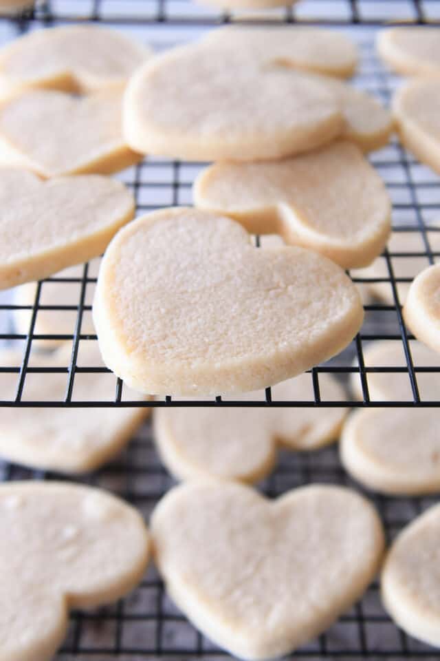 Heart shaped sugar cookies on baking cooling rack.