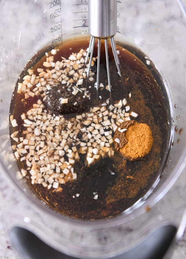 liquid measuring cup with garlic, soy sauce, brown sugar, curry powder