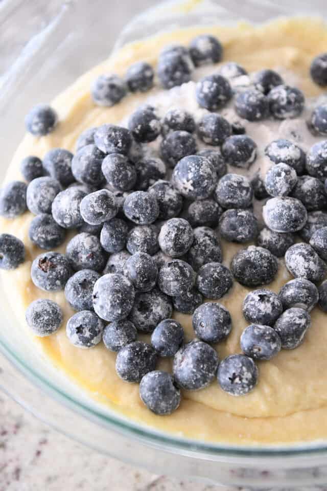 Lightly floured blueberries in bowl with cake batter.