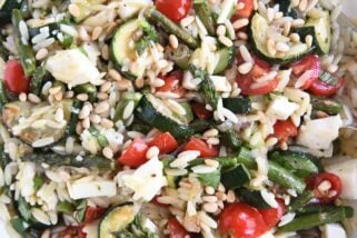 close up view of orzo, pine nuts, zucchini, cherry tomatoes, asparagus, and fresh mozzarella
