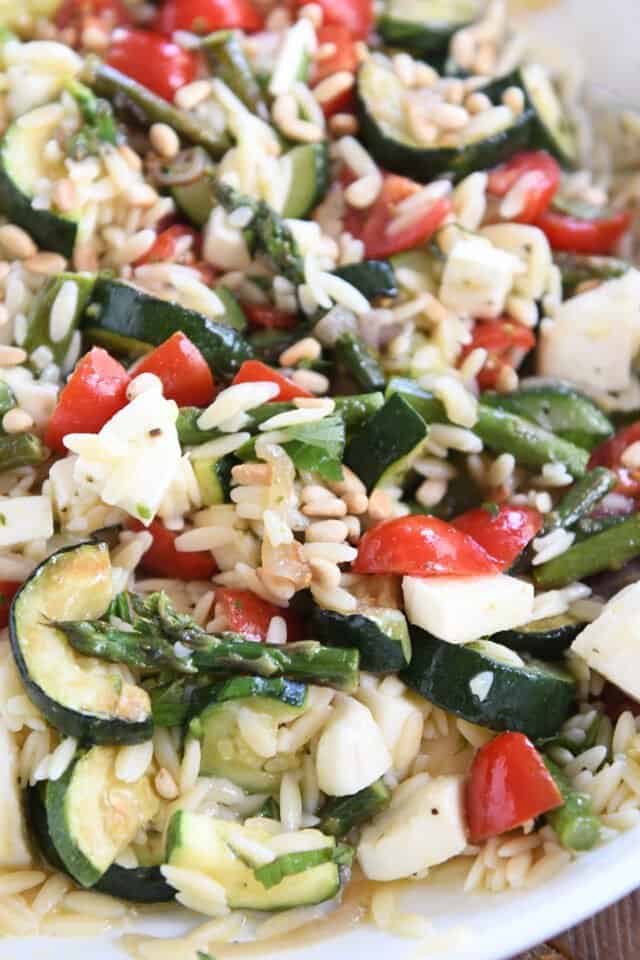 Lemon orzo salad in white bowl with roasted vegetables.