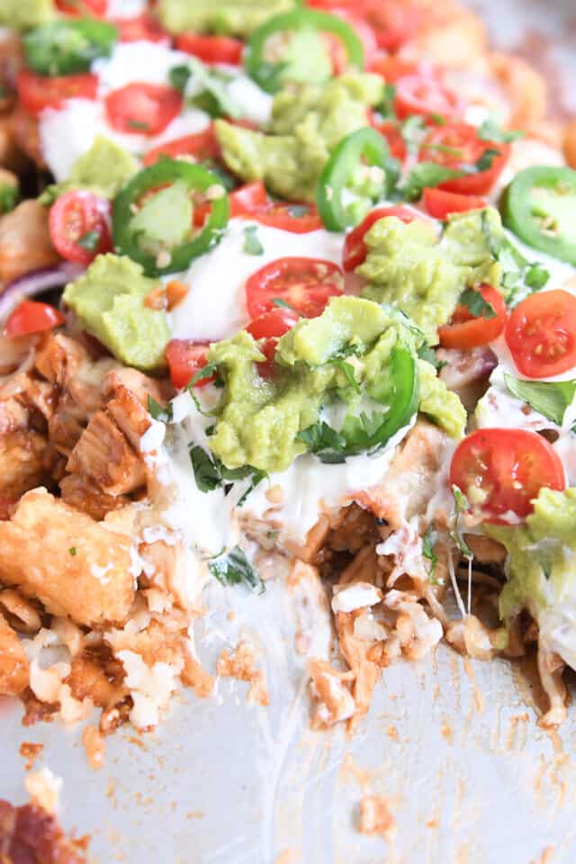 BBQ chicken tater tot nachos on sheet pan with helping taken out.