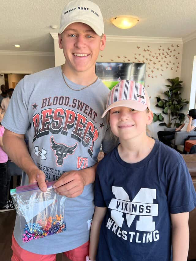 boy and girl holding bag of beads