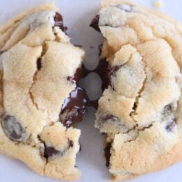 super soft chocolate chip cookie broken in half with melted chocolate chips