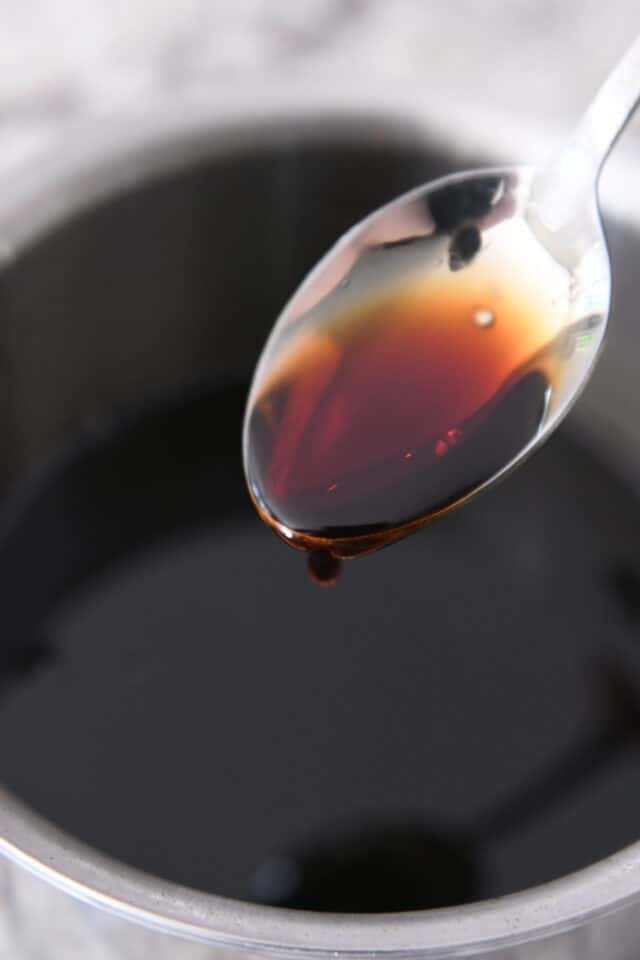 Spoon with drip of teriyaki sauce.