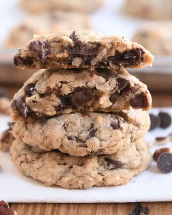 Two cowboy cookies stacked with one cookie broken in half on top.