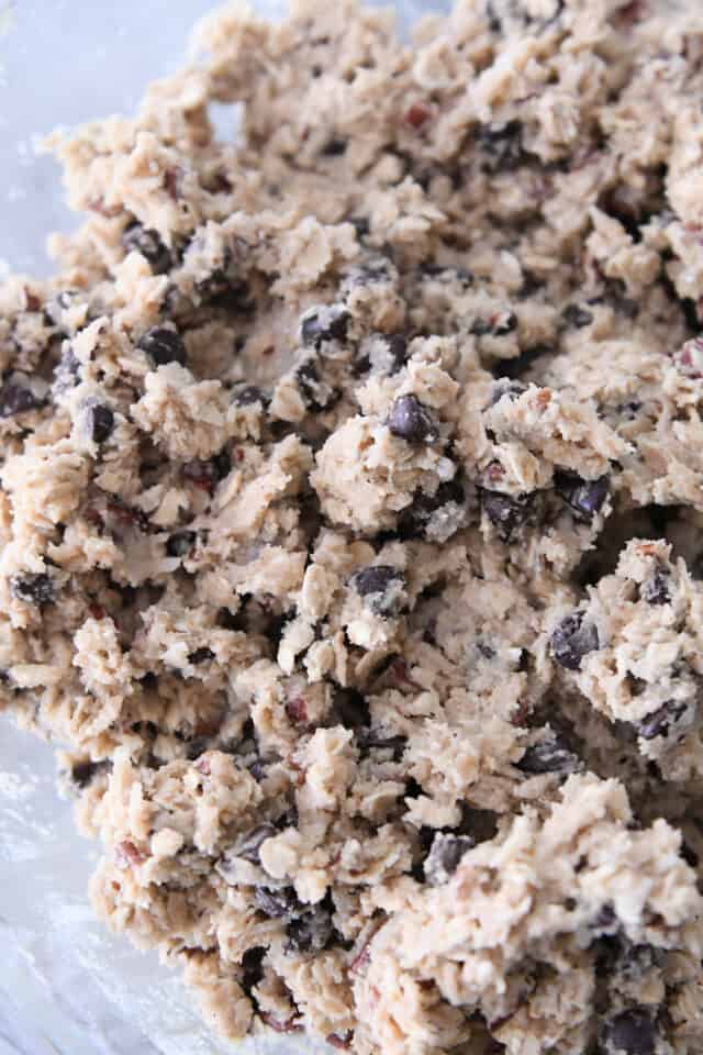 Cowboy cookie dough with coconut, oats, pecans and chocolate chips in glass bowl.