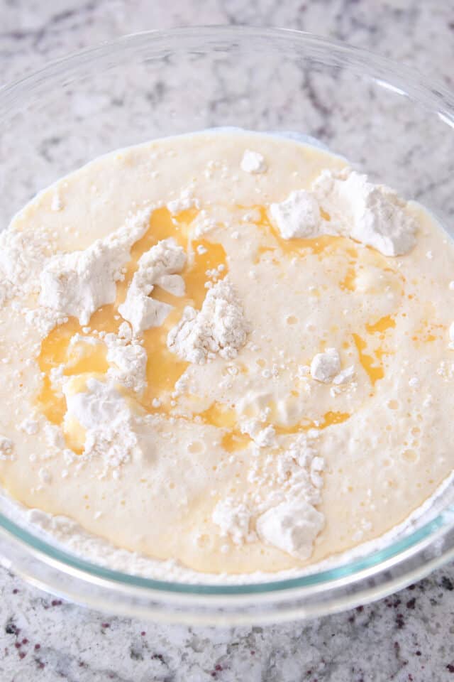 Glass bowl with flour, butter, eggs and milk.