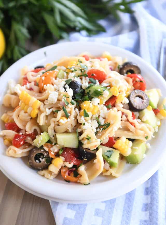 Serving of Greek pasta salad on white plate.