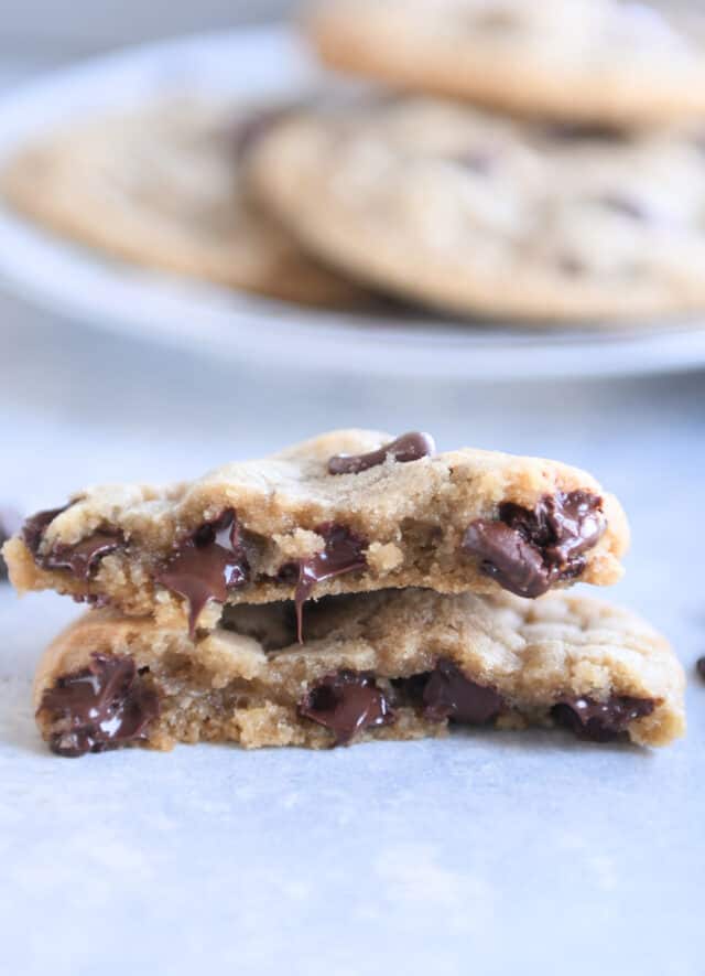 One chocolate chip cookie broken in half with melty chocolate chips.