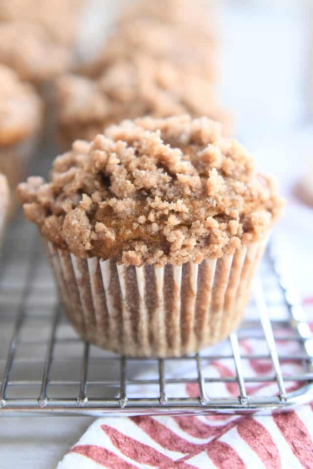 Streusel topped pumpkin snickerdoodle muffin on cooling rack.