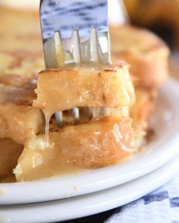 Fork piercing two bites of French toast.