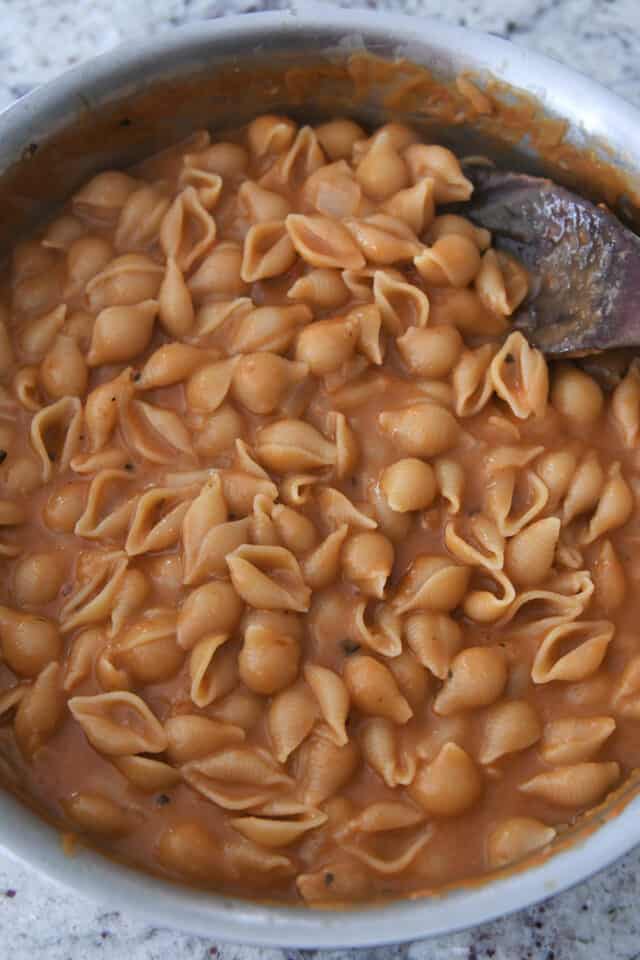 Creamy cooked pasta shells in pan.