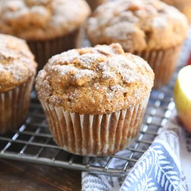 Baked muffins with cinnamon and sugar topping on cooling rack.