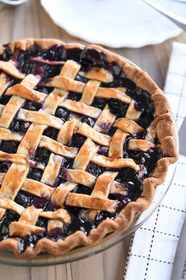 Lattice topped triple berry pie in glass pie plate.