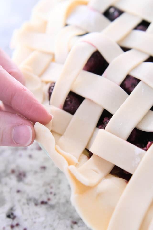 Fold the edges of the pie crust into a grid.