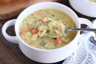 White bowl with spoon scooping up chicken and wild rice soup.