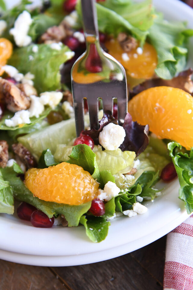 Eat salad greens, feta cheese, tangerines, and pomegranate seeds with a fork.