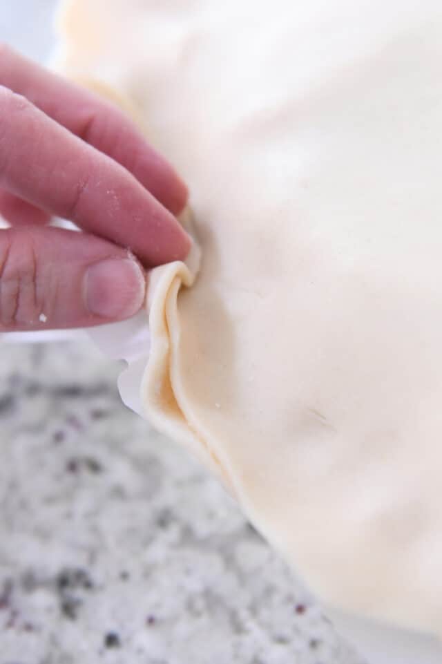 Folding over bottom pie crust.