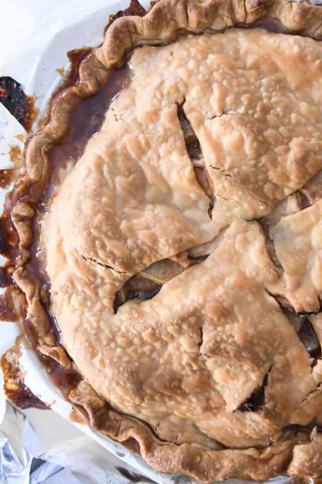 Baked apple pie with caramel around edges.
