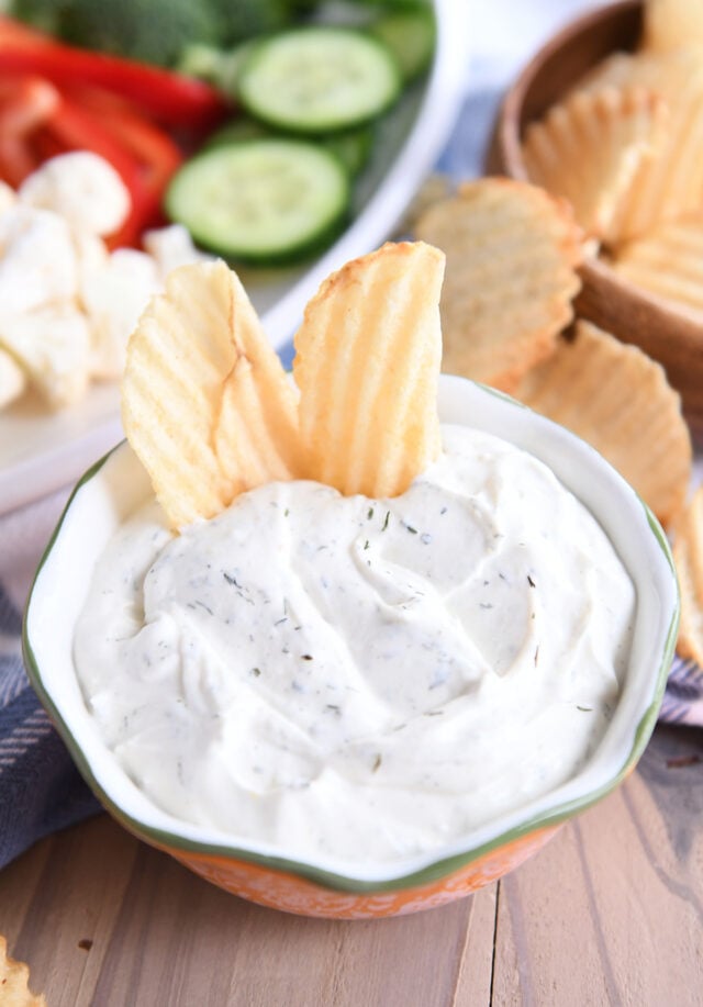 Two wavy potato chips in dip.