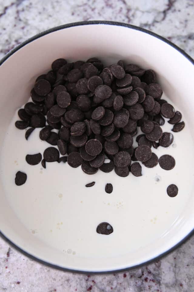 Chocolate chips and cream in fondue pot.