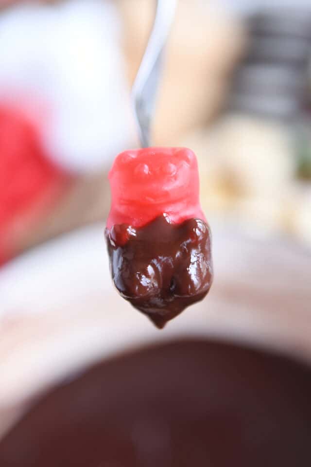 Dipping a cinnamon bear in chocolate fondue.