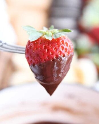 Chocolate dipped strawberry on fondue fork.