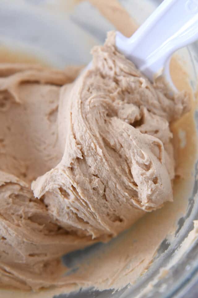 Glass bowl of creamy peanut butter frosting.