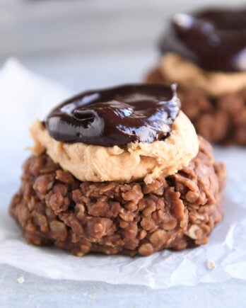 No bake cookie with peanut butter frosting and ganache on white parchment paper.