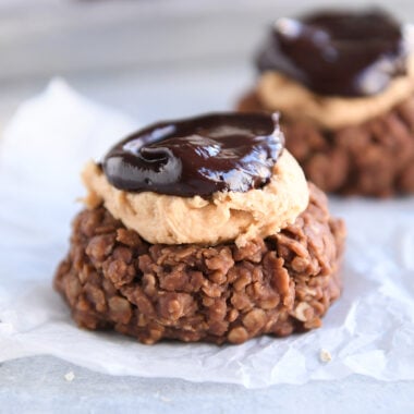 No bake cookie with peanut butter frosting and ganache on white parchment paper.
