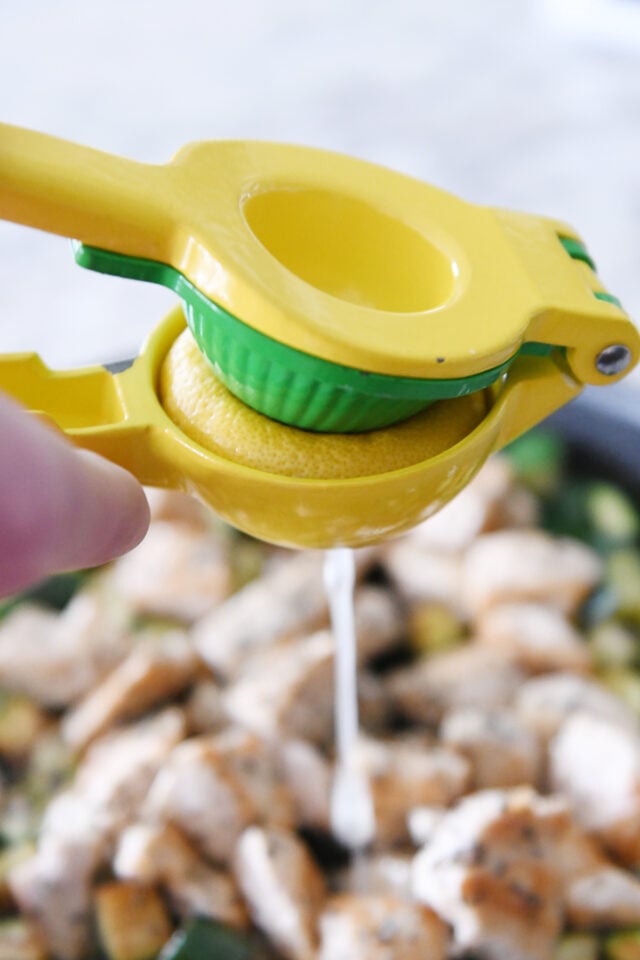 Squeezing lemon through citrus press.