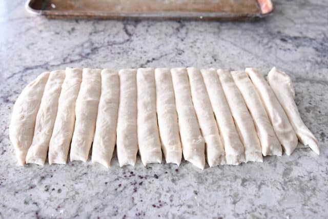 Breadsticks cut in strips on counter.