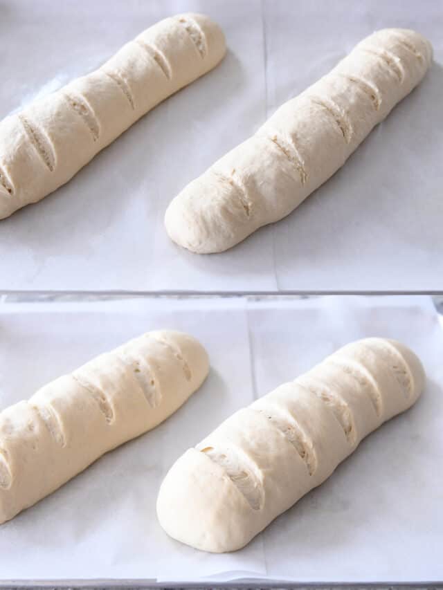 French bread dough loaves rising on parchment paper.