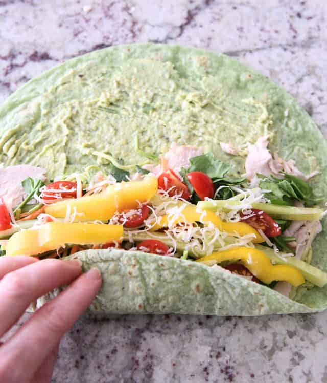 Roll up the turkey avocado veggie wrap.