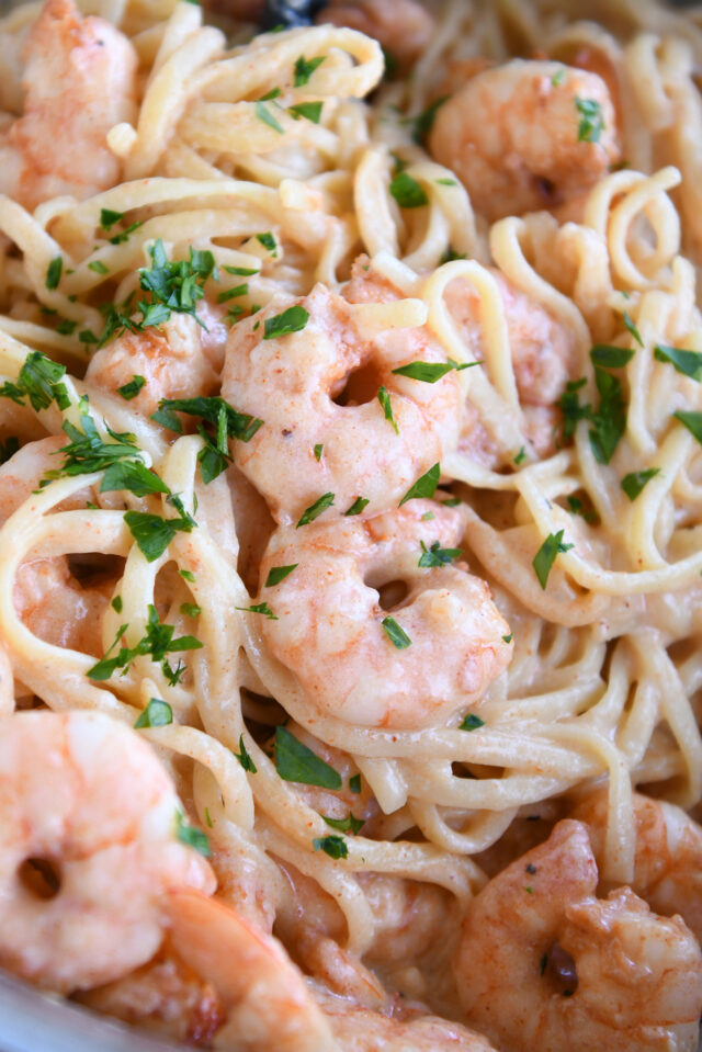 Linguine pasta with cream sauce, cooked shrimp and fresh parsley.