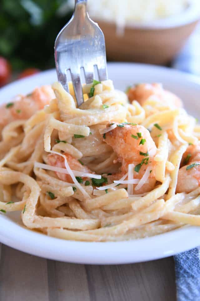 Twisting fork in creamy linguine with shrimp.