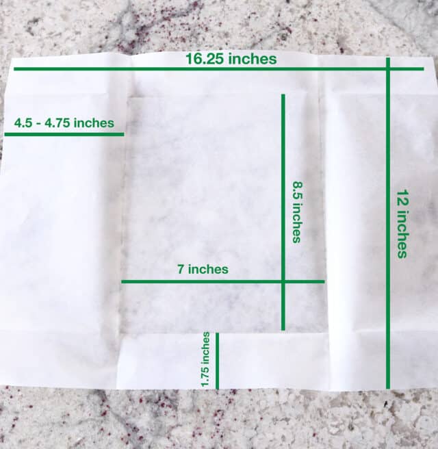 Parchment paper with lines and dimensions for folding.