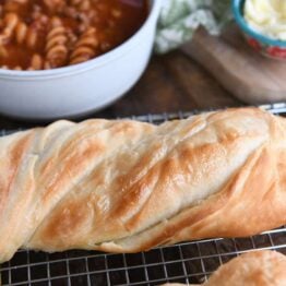 Loaf of twisted croissant French bread on cooling rack.