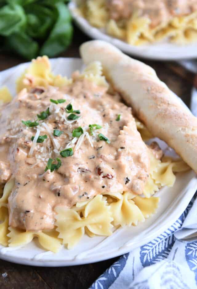 Creamy pasta sauce with parmesan cheese and basil on bowtie pasta.