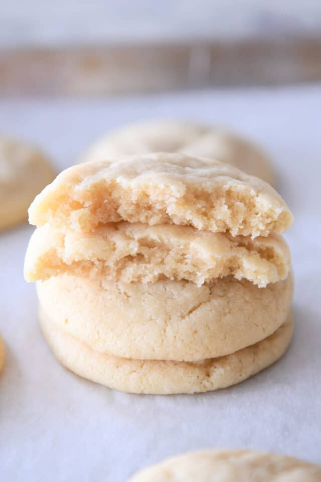 Two halves of sugar cookies stacked on two cookies.