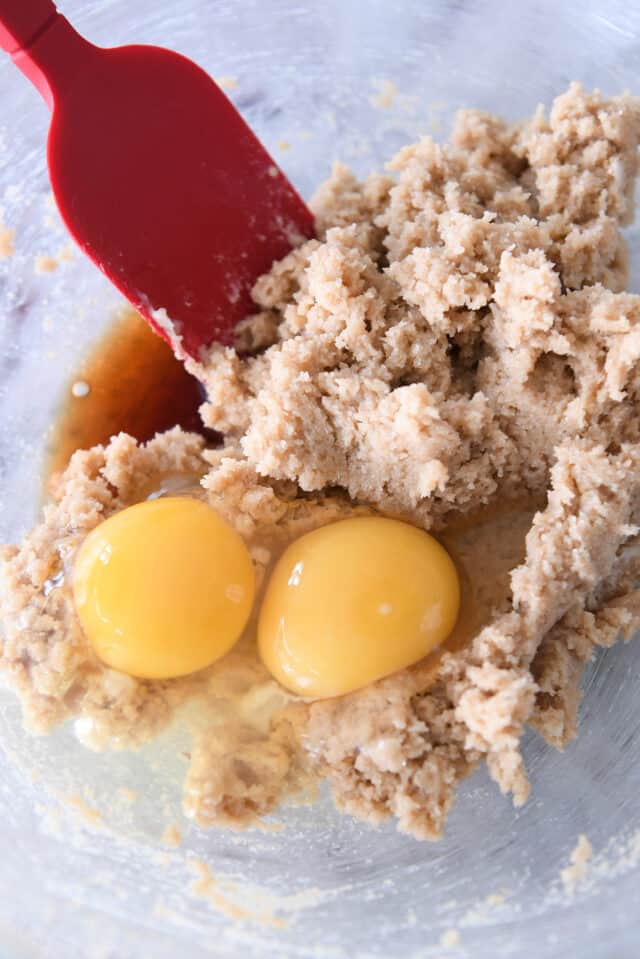 Glass bowl with butter and brown sugar whipped with eggs in glass bowl.