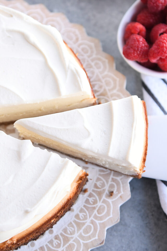 Pulling slice of cheesecake out of whole cheesecake.