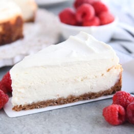 Slice of vanilla bean cheesecake on white spatula.