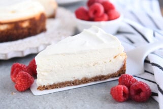 Slice of vanilla bean cheesecake on white spatula.