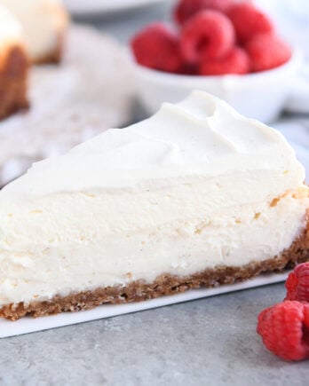 Slice of vanilla bean cheesecake on white spatula.